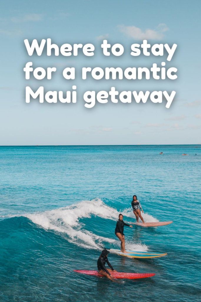 Three people surfing on blue ocean waves under a clear sky, with white text above reading Where to stay for a romantic Maui getaway featuring the best romantic hotels in Maui.