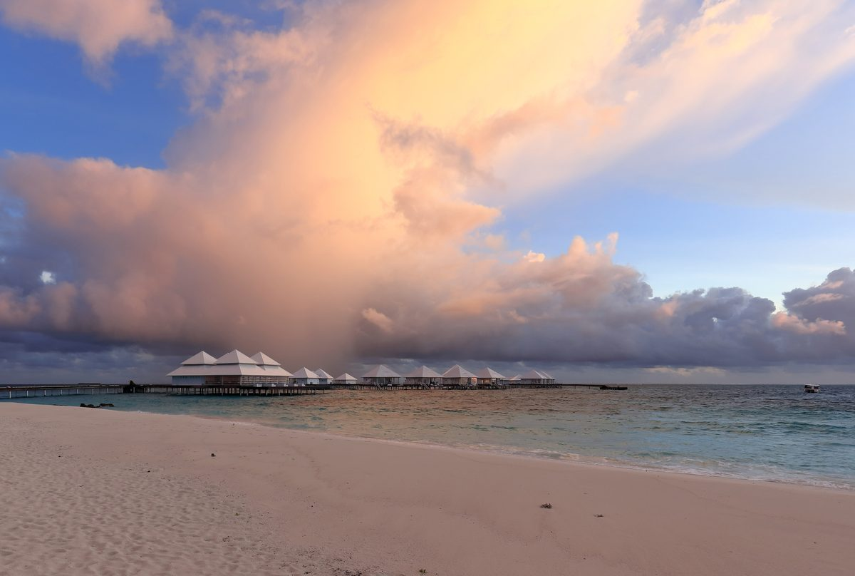 A Maldives resort combining overwater villas with a beach and island backdrop