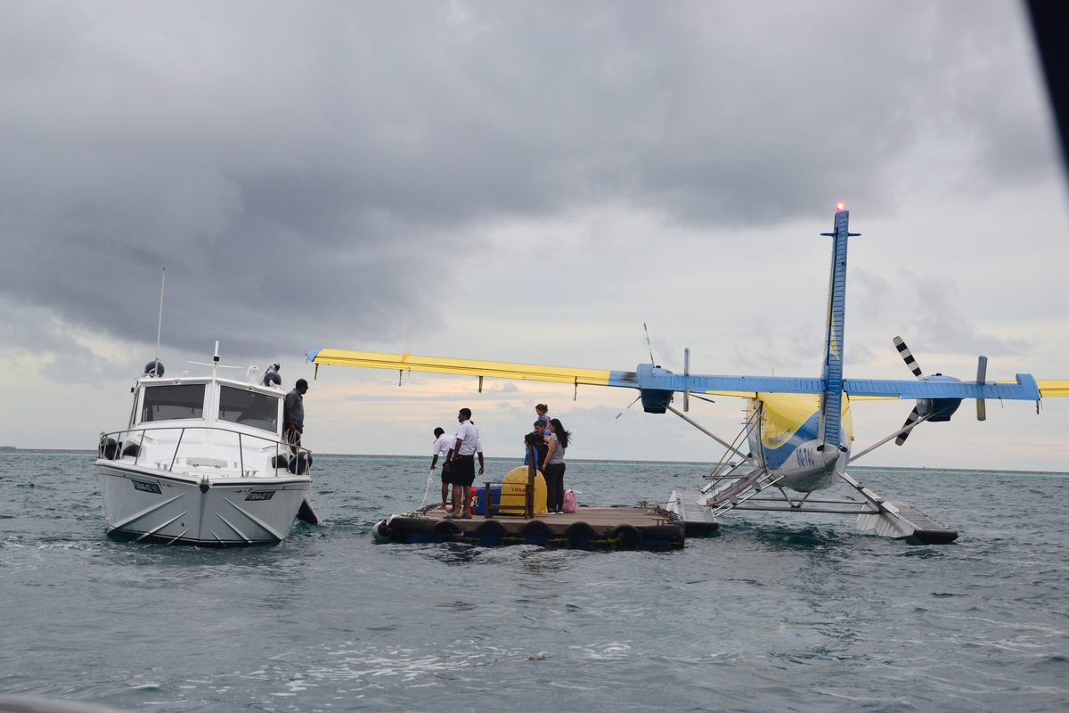 A seaplane used for resort transfers, docked beside a boat in the Maldives